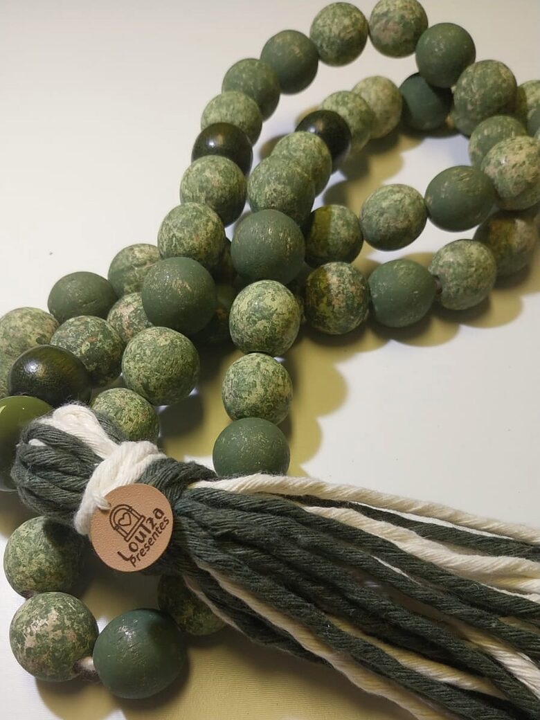 Colar de mesa em contas verdes mescladas, com borla em fio verde e cru e a etiqueta Louiza Presentes.